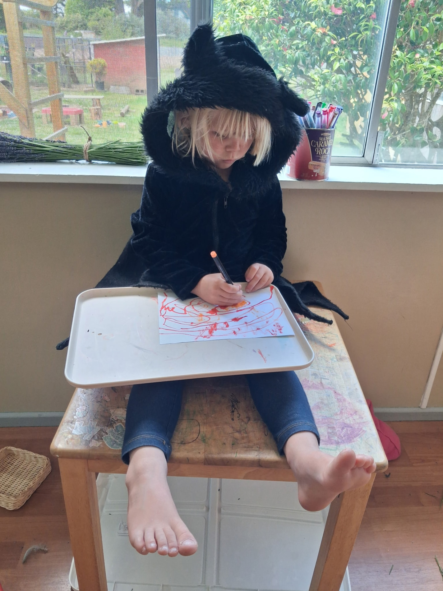 Child drawing at a small table on a foggy Humboldt County morning